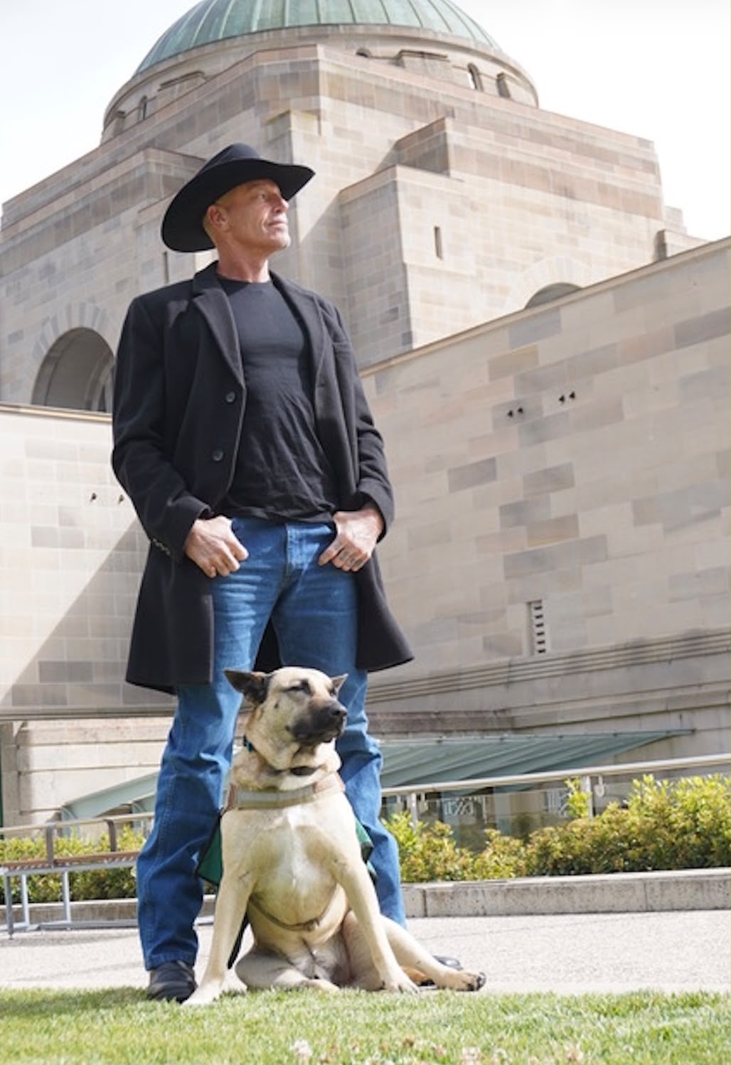 Deep Root program participant with his service dog outside a war memorial